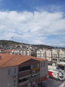 a city with buildings and a flag on a hill at Çeşme MASAL in Çeşme +27 photos