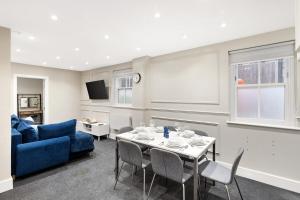 a living room with a table and a blue couch at Spacious 2-Bed Home in Chipping Barnet in Barnet