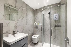 a bathroom with a shower and a toilet and a sink at Spacious 2-Bed Home in Chipping Barnet in Barnet