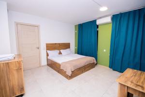 a bedroom with a bed and blue curtains in it at The Best Hostel in Yerevan +30 photos