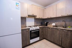 a kitchen with wooden cabinets and a white stove top oven at The Best Hostel in Yerevan