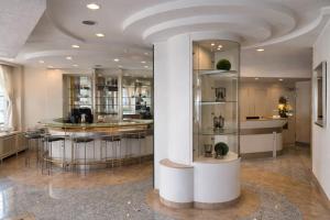 a lobby with a bar with stools at Hotel Carlton in Duisburg