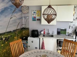 a kitchen with a table and a kitchen with a painting on the wall at Janka B&B in Elim +13 photos