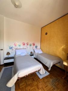 two beds in a room with umbrellas on the wall at Paolo&SilviaHost in Seriate