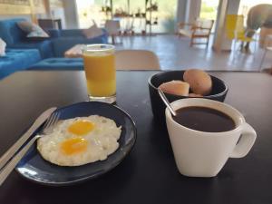 a black table with a plate of eggs and a cup of coffee at Shambala Hostel in Huacachina