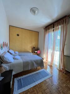 a bedroom with two beds and a large window at Paolo&SilviaHost in Seriate
