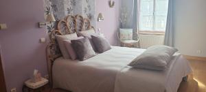 a bedroom with a large bed with white sheets and pillows at DEMEURE DU VIVIER in Appenai-sous-Bellême