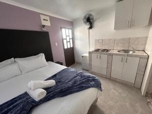 a bedroom with a large bed and a sink at Black & White Guest House in Parow