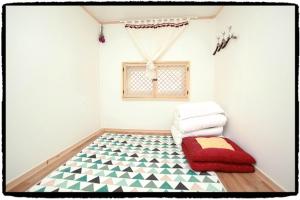 uma sala de estar com piso em xadrez e uma janela em Dowon Guesthouse em Jeonju