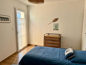 a bedroom with a bed and a dresser and a window at Le Clos des Embruns in Chassiron
