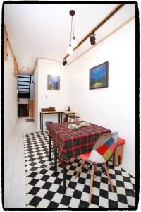 a dining room with a table and a checkered floor at Dowon Guesthouse in Jeonju