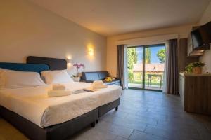 a bedroom with a large bed and a living room at Club del Sole Desenzano Boutique Resort in Desenzano del Garda +99 photos