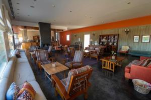 a restaurant with couches and tables and chairs at Hotel Territorio in Puerto Madryn