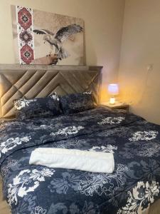 a bedroom with a bed with a blue and white blanket at RUBA apartment in Dammam