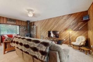 a living room with a couch and a television at Spacious home with full kitchen wifi private backyard & grill in Welches