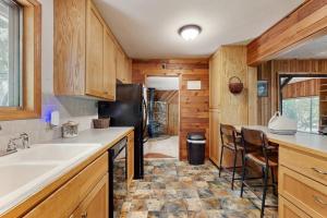 a kitchen with a sink and a refrigerator at Spacious home with full kitchen wifi private backyard & grill in Welches