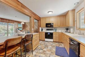 a kitchen with wooden cabinets and a table and chairs at Spacious home with full kitchen wifi private backyard & grill in Welches +17 photos