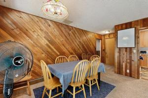 a dining room with a table and chairs and a fan at Spacious home with full kitchen wifi private backyard & grill in Welches