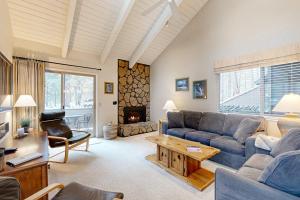 a living room with a couch and a fireplace at Comfortable condo with shared pool SHARC passes trails and more in Sunriver