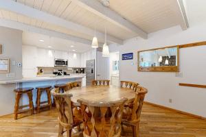 a kitchen and dining room with a wooden table and chairs at Comfortable condo with shared pool SHARC passes trails and more in Sunriver