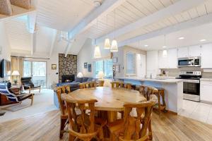 a kitchen and living room with a wooden table and chairs at Comfortable condo with shared pool SHARC passes trails and more in Sunriver +30 photos