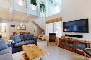 a living room with a couch and a tv at Comfortable condo with shared pool SHARC passes trails and more in Sunriver