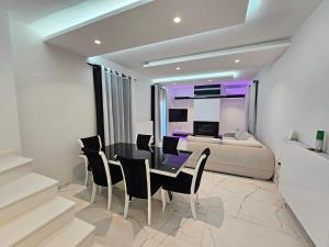 a living room with a table and chairs and a couch at GREY LUXURY HOUSE in Ipsos