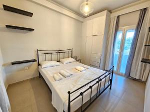 a bedroom with a bed with white sheets and pillows at GREY LUXURY HOUSE in Ipsos