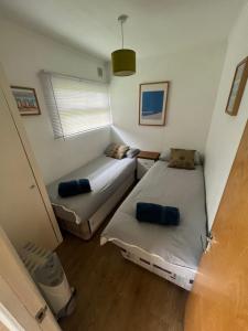 a small room with two beds and a window at Cromer Coastal Retreat Kings Chalet Park in Cromer
