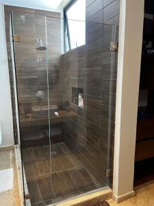 a shower with a glass door in a bathroom at Chicxulub , oceanfront 3 recamaras in Chicxulub +23 photos