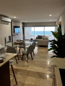 a living room with a couch and a table and chairs at Chicxulub , oceanfront 3 recamaras in Chicxulub
