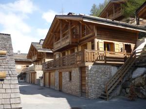 イゾラ 2000にあるSCI Chalet Dempureのバルコニーと階段が備わる大きな木造家屋です。