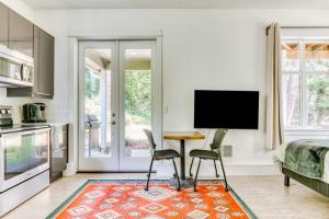 a living room with a table and two chairs and a television at Dog-friendly studio with river view patio grill & shared W&D in Stevenson