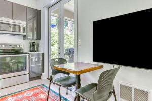 a kitchen with a table and chairs and a flat screen tv at Dog-friendly studio with river view patio grill & shared W&D in Stevenson