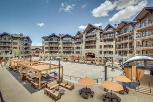an apartment complex with a patio with tables and chairs at Cozy condo with mountain views free shuttle & W&D in Ponderosa Fairway Estates