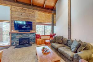 a living room with a couch and a fireplace at Cozy condo with mountain views free shuttle & W&D in Ponderosa Fairway Estates