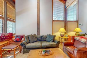 a living room with a couch and a table at Cozy condo with mountain views free shuttle & W&D in Ponderosa Fairway Estates