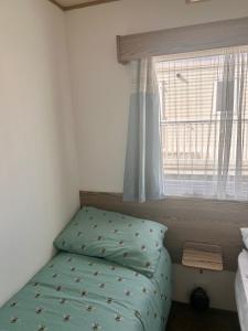 a small bedroom with a bed and a window at Spacious Holiday Home in Exmouth Ocean Views and Pet Friendly in Exmouth +21 photos