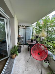 a red umbrella sitting on a balcony with a table at Appartement T2 à Chelles - Paris, CDG & Disneyland à proximité, parking privé in Chelles