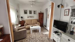 a living room with a couch and a tv at La Casita in Torrox