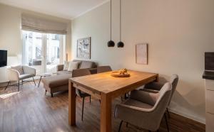 a living room with a wooden table and chairs at Rodehuus Wohnung 2 in Borkum