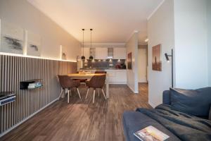 a living room and kitchen with a table and chairs at Rodehuus Wohnung 10 in Borkum