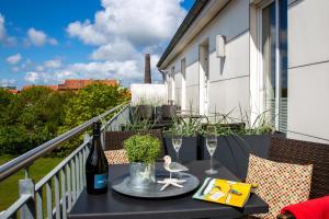 a table with a bottle of wine and a bird on a balcony at Rodehuus Wohnung 10 in Borkum