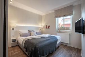 a bedroom with a large bed and a window at Rodehuus Wohnung 10 in Borkum +3 photos