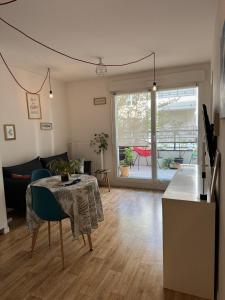 a living room with a table and a couch at Appartement T2 à Chelles - Paris, CDG & Disneyland à proximité, parking privé in Chelles
