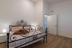 a bedroom with a black metal bed with pillows at Serraglia Guest House in San Trovaso
