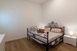 a bed in a room with a white wall at Serraglia Guest House in San Trovaso