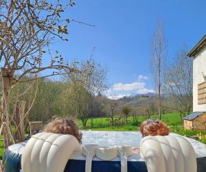 two people sitting in chairs by a swimming pool at Coume a Case - Maison de charme 4 étoiles - piscine et spa - vallée d'Ossau in Lys