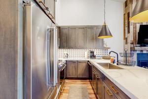 a kitchen with wooden cabinets and a stainless steel refrigerator at Ski and Ski Out Designer Condo With a View in Kingswood Estates