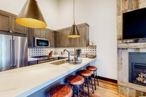 a kitchen with a sink and a counter with stools at Ski and Ski Out Designer Condo With a View in Kingswood Estates